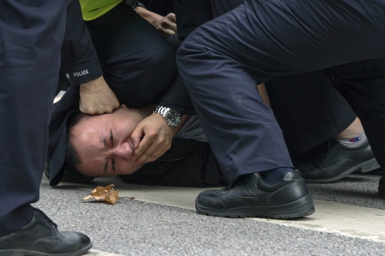 Policemen pin down and arrest a protester during a protest on a street in Shanghai, China, on Nov. 27, 2022. Authorities eased anti-virus rules in scattered areas but affirmed China's severe 