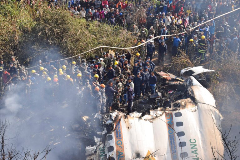 Nepalese rescue workers and civilians gather around the wreckage of a passenger plane that crashed in Pokhara, Nepal, Sunday, Jan. 15, 2023. 