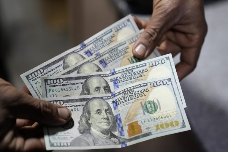 A Pakistani money trader shows U.S. 100 dollar notes at a currency exchange office, in Lahore, Pakistan, Thursday, Jan. 28, 2023. (AP Photo/K.M. Chaudary)
