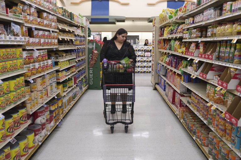 Jaqueline Benitez pushes her cart down an aisle as she shops for groceries at a supermarket in Bellflower, Calif., on Monday, Feb. 13, 2023.