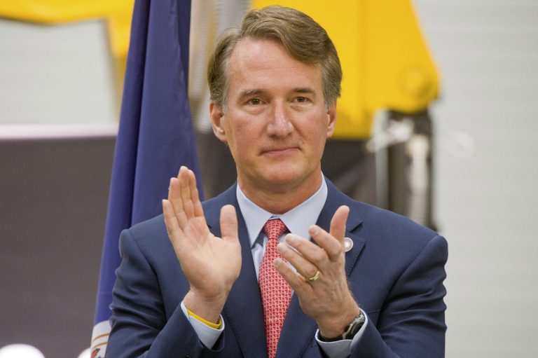 FILE - Virginia Gov. Glenn Youngkin listens to another speaker before he delivered remarks about his proposed tax relief package for individuals and businesses during a news conference at Carter Machinery, Thursday, Jan. 5, 2023, in Salem, Va. (Scott P. Yates/The Roanoke Times via AP, File)
