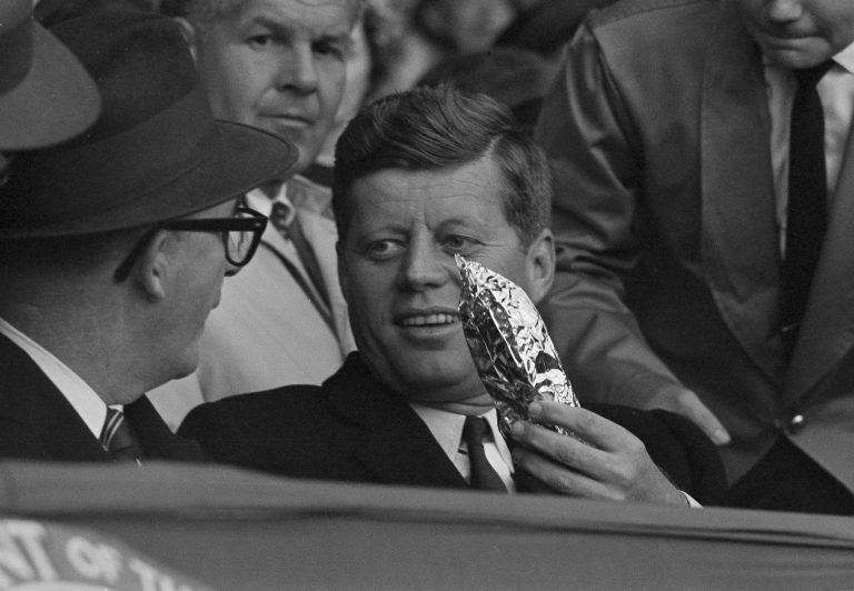 President John F. Kennedy holds a bag of popcorn in the presidential box as he passes it along to Vice President Lyndon Johnson during the American League baseball opener between the Chicago White Sox and the new Washington Senators, April 10, 1961. JFK was the king of nasty nicknames, and dubbed LBJ "Rufus Cornpone," according to a new book.