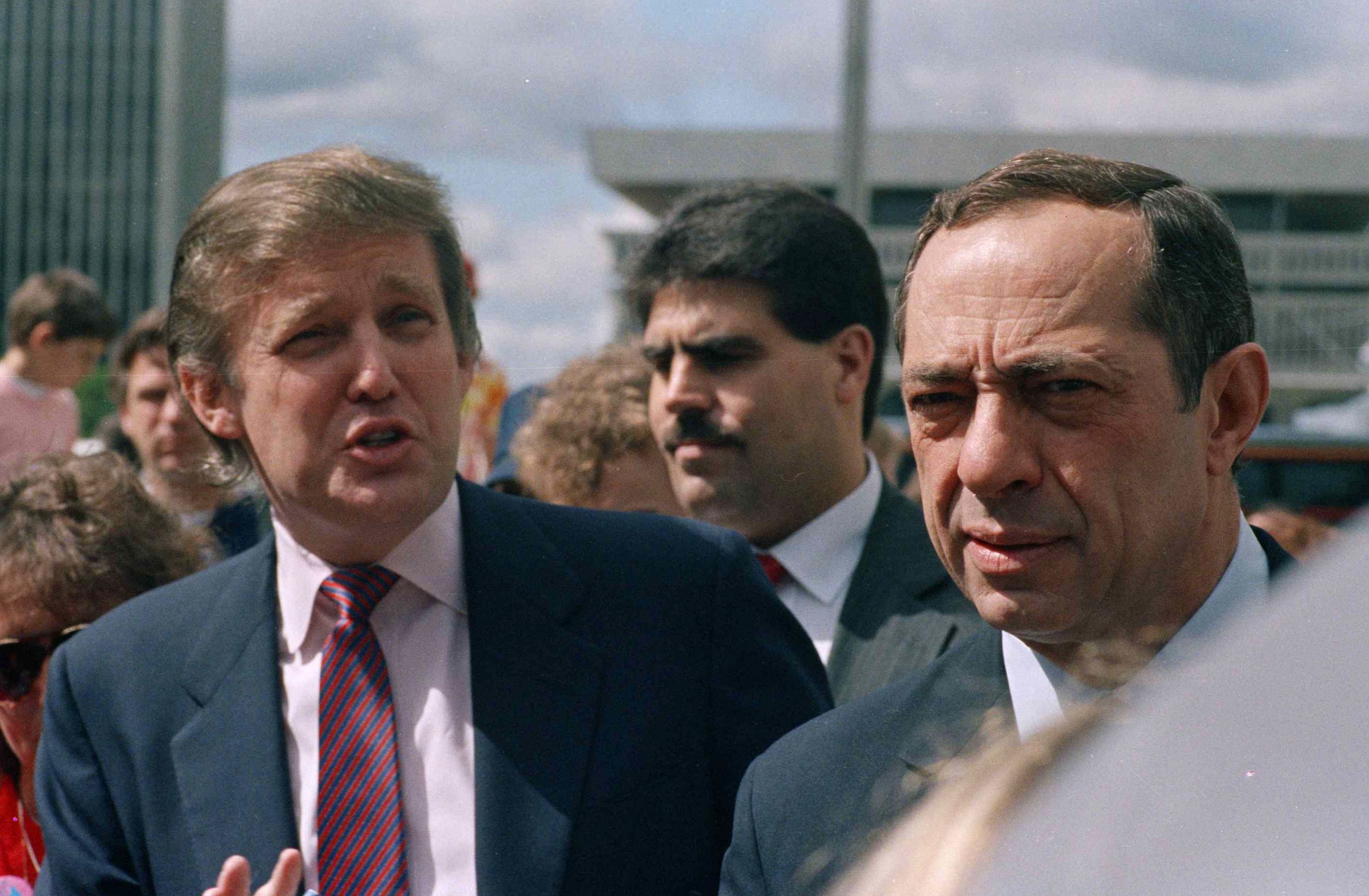 Developer Donald Trump and New York State Gov. Mario Cuomo get together before the start of the Tour De Trump bicycle race in Albany, New York, on May 6, 1989.