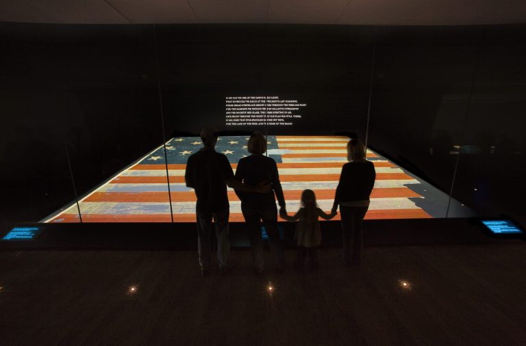 This handout photo provided by the Smithsonian Institution, taken in Nov. 2008, shows a family viewing the Star Spangled Banner at the Smithsonian's National Museum of American History in Washington. Girl Scouts, Little League players and musicians including Phish and Train are joining a national sing-a-long to celebrate the 200th anniversary of the national anthem and the flag that inspired its lyrics. The National Museum of American History is coordinating the celebration Saturday, which is Flag Day. (AP Photo/Hugh Talman, Smithsonian Institution)