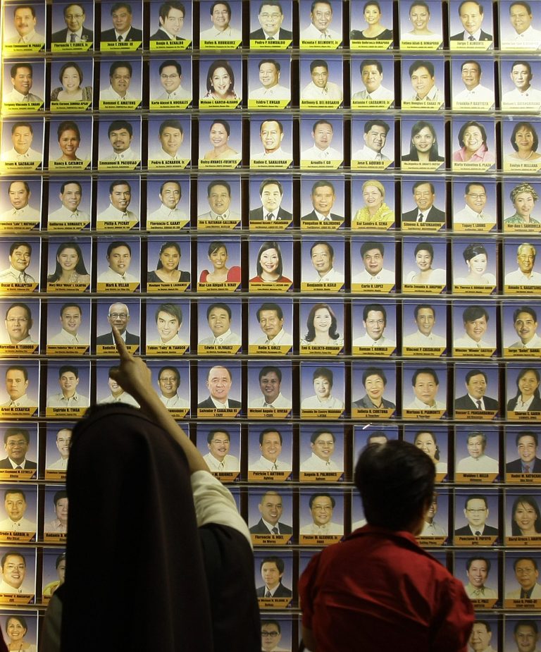   A Filipino Catholic nun and an anti-Reproductive Health bill supporter look at pictures of Philippine legislators as they passed a landmark law that would provide government funding for contraceptives and sexuality classes during a session at the Philippine Congress in suburban Quezon City, north of Manila, Philippines on Monday Dec. 17, 2012. Philippine legislators passed the law despite strong opposition by the dominant Roman Catholic Church and its followers, some of whom threatened to ask the Supreme Court to thrash the legislation. (AP Photo/Aaron Favila)  