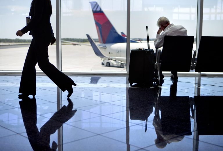 A passenger sits at right in the international terminal at Hartsfield-Jackson airport, Friday, April 26, 2013, in Atlanta. Congress easily approved legislation Friday ending furloughs of air traffic controllers that have delayed hundreds of flights daily, infuriating travelers and causing political headaches for lawmakers.(AP Photo/David Goldman)