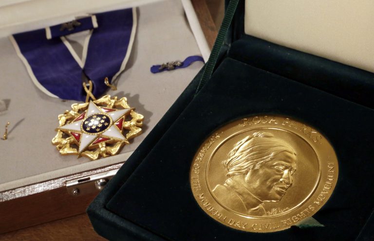 FILE - In this March 14, 2014, file photo, Rosa Parks' Presidential Medal of Freedom, left, and her Congressional Gold Medal are displayed at Guernsey's auction house, in New York. Hundreds of items from the civil rights figure Rosa Parks that were long kept hidden away in a warehouse will have a new home at the Library of Congress for the next 10 years. (AP Photo/Richard Drew, File)