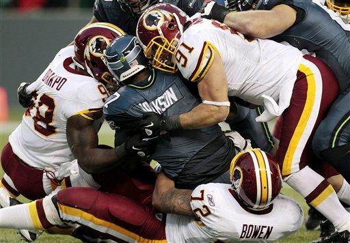 Seattle Seahawks quarterback Tarvaris Jackson is sacked for a nine-yard loss by Washington Redskins' Stephen Bowen (72) and Brian Orakpo, left, as Ryan Kerrigan (91) comes in late in the second half of an NFL football game, Sunday, Nov. 27, 2011, in Seattle. The Redskins won 23-17.