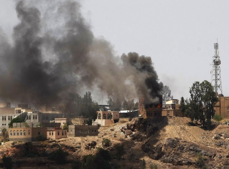 Smokes rises from near the Yemeni Government TV building, background, during clashes between Sunni militiamen and Hawthi Shiite rebels in Sanaa, Yemen, Saturday, Sept. 20, 2014. The Hawthi fighters and militias and army units allied with the Muslim Brotherhood's Islah party battled in Sanaa for a third day Saturday in clashes that have shaken the Yemeni capital, killed over 120 people, and led to thousands fleeing their homes. The violence raises fears that this chronically unstable country could be dragged into the sort of sectarian conflicts that have plagued other nations in the region. (AP Photo/Hani Mohammed)