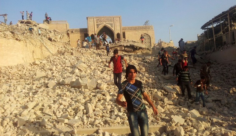 People walk on the rubble of the destroyed Mosque of The Prophet Younis, or Jonah, in Mosul, Iraq. (AP Photo, File)