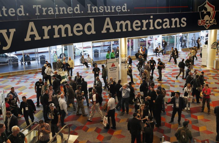 People walk through halls outside of the SHOT Show gun show Wednesday, Jan. 24, 2018, in Las Vegas. (AP Photo/John Locher)
