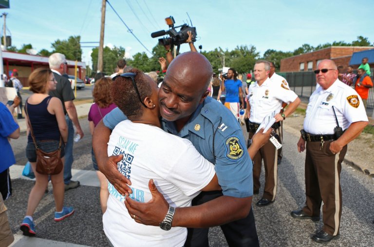 Capt. Ronald Johnson of the Missouri Highway Patrol hugs Angela Whitman, of Berkeley, Mo., on West Florissant Avenue in Ferguson, Mo., on Thursday. (AP Photo/St. Louis Post-Dispatch, David Carson)
