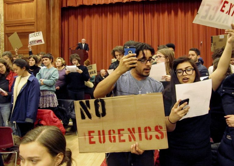 Middlebury College students turn their backs to Charles Murray, who they call a white nationalist, during his lecture in Middlebury, Vt., Thursday, March 2, 2017. Hundreds of college students on Thursday protested the lecture, forcing the college to move his talk to an undisclosed campus location from which it was live-streamed to the original venue but couldn't be heard above protesters' chants, feet stamping and occasional smoke alarms. (AP Photo/Lisa Rathke)