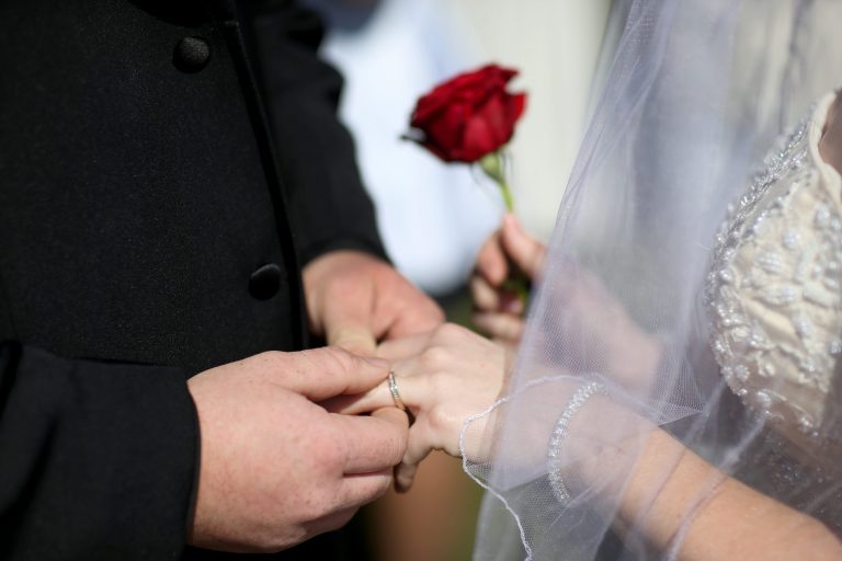 A couple exchanges rings as they are wed during a group Valentine's day wedding at the National Croquet Center on February 14, 2014 in West Palm Beach, Florida. (Photo by Joe Raedle/Getty Images)