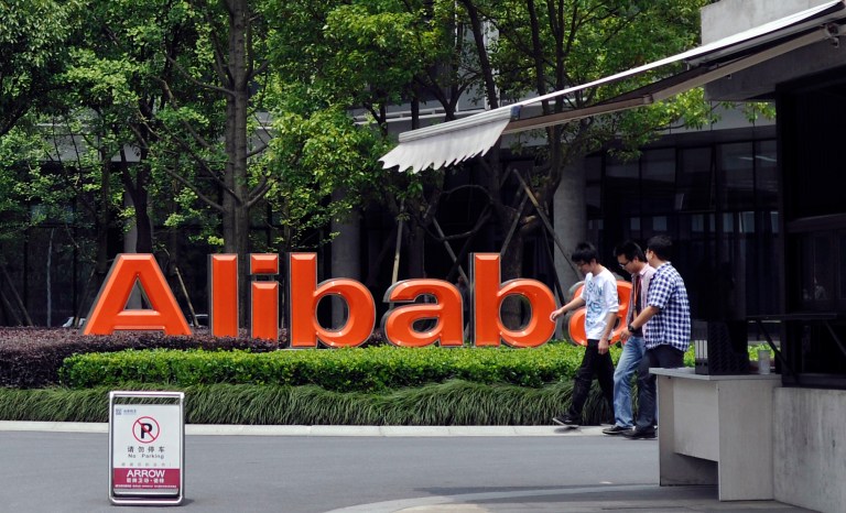 FILE - In this May 21, 2012 file photo, men walk past the corporate logo at the headquarters compound of Alibaba Group in Hangzhou in eastern China's Zhejiang province. Alibaba Group is aiming to raise $1 billion in a long-awaited IPO likely to have ripple effects across the Internet. The Tuesday, May 6, 2014 filing sets the stage for the technology industry's biggest initial public offering since short messaging service Twitter and its early investors collected $1.8 billion in its stock market debut last fall. (AP Photo/File) CHINA OUT