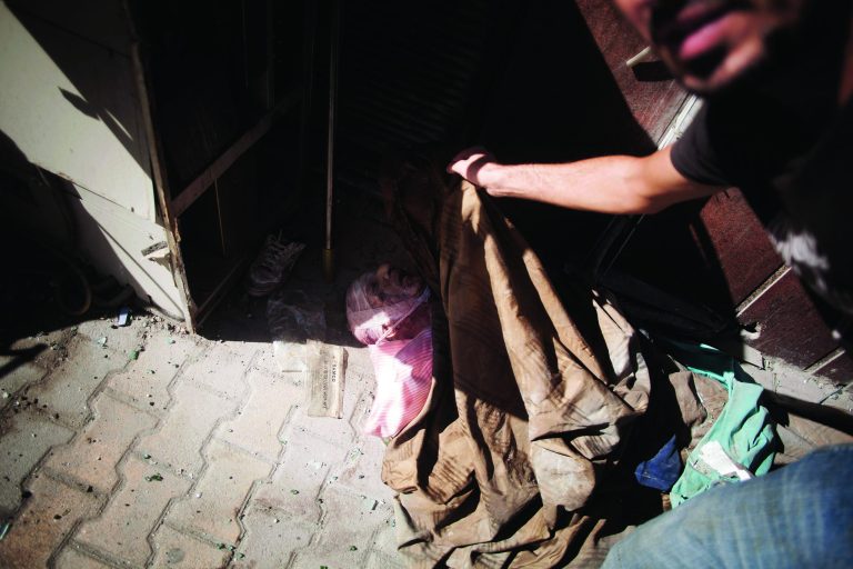 In this Wednesday, Sept. 19, 2012 photo, the body of an elderly man, said by rebels to be a Coptic Christian, lies at the door of a hospital controlled by the Free Syrian Army in Aleppo, Syria.(AP Photo/Manu Brabo)