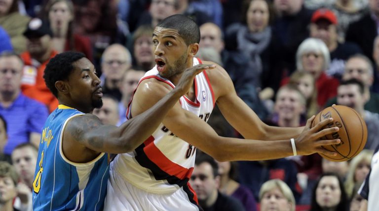   Portland Trail Blazers forward Nicolas Batum, right, from France, looks for help as New Orleans Hornet guard Roger Mason, Jr., defends during the first quarter of an NBA basketball game in Portland, Ore., Sunday, Dec. 16, 2012.(AP Photo/Don Ryan)  