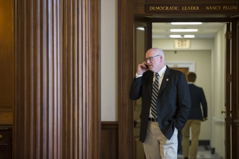 Rep. Joseph Crowley, D-N.Y., makes a phone call outside the office of House Minority Leader Nancy Pelosi as Democrats gather before voting, at the Capitol in Washington, Saturday, Oct. 5, 2013. With the partial shutdown entering its fifth day, the GOP-run House passed a bill Saturday that would make sure the furloughed workers get paid for not working. The White House backs the bill and the Senate was expected to OK it, too, but the timing was unclear. The 407-0 vote in the House was uniquely bipartisan, even as lawmakers continued their partisan rhetoric.  (AP Photo/J. Scott Applewhite)