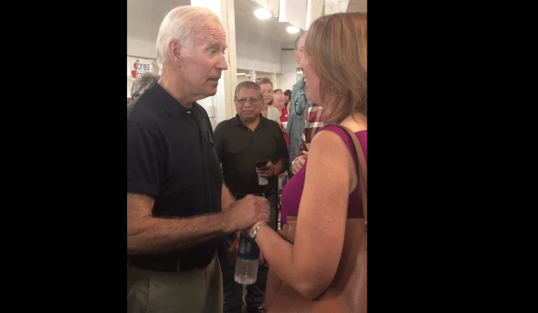 Joe Biden grabs the hand of an Iowa teacher. 