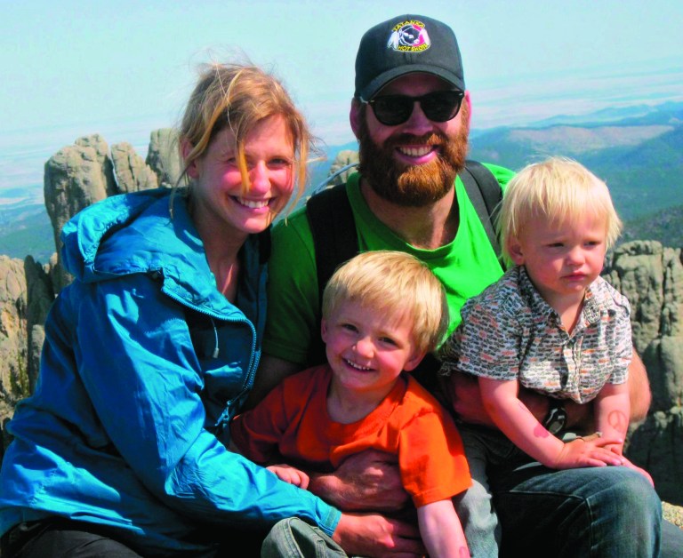 This May 13, 2012, family photo provided by Nathan Ochs shows his wife, Constance Van Kley, Nathan Ochs and their sons Rudy, left, and Abraham during a visit to Little Devils Tower near Custer, S.D. If hotshot firefighter Nathan Ochs is hurt on the job, workers compensation would pay for his medical care. When his son Rudy was born seven weeks premature, Ochs and his wife were left with a $70,000 hospital bill because they had no health insurance. Thousands of wildland firefighters aren't eligible for federal health insurance so they have launched an online petition to change that_ drawing more than 90,000 signatures in a matter of days. (AP Photo/Ochs Family)