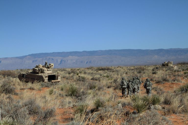 A group of soldiers proceed toward armored vehicles after a training exercise at Ft. Bliss, Texas, Wednesday, Jan. 23, 2013. The army is rolling out a new training platform that allows the integration of live units, simulators and computer generated forces. It is expected to allow cheaper, more frequent training. (AP Photo/Juan Carlos Llorca)