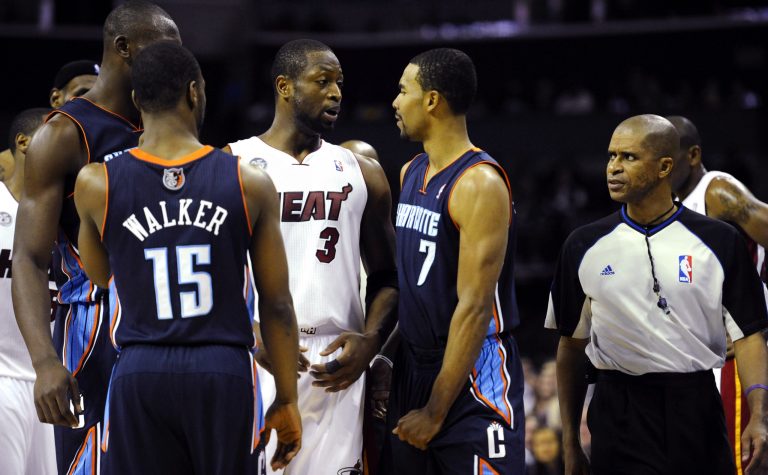   Miami Heat's Dwyane Wade (3) and Charlotte Bobcats' Ramon Sessions (7) interact after Sessions was called for a foul as referee Zach Zarba (33) watches during the second half of their NBA basketball game, Wednesday, Dec. 26, 2012, in Charlotte. The Heat won 105-92. (AP Photo/The Charlotte Observer, David T. Foster III) MAGS OUT; TV OUT; NEWSPAPER INTERNET ONLY  