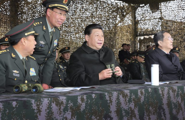 In this photo provided by China's official Xinhua News Agency, Chinese President Xi Jinping, center, watches drills of troops of the Chinese People's Liberation Army in northwest China's Xinjiang Uighur Autonomous Region Thursday, May 1, 2014. Chinese President Xi demanded 