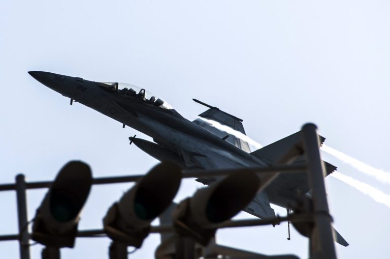 In this image provided by the U.S. Navy a F/A-18F Super Hornet attached to the Fighting Black Lions of Strike Fighter Squadron flies over the aircraft carrier USS George H.W. Bush in the Persian Gulf on Tuesday, Sept. 23, 2014, after conducting strike missions against Islamic State group targets in Syria. (AP Photo/U.S. Navy, Mass Communication Specialist 3rd Class Brian Stephens)