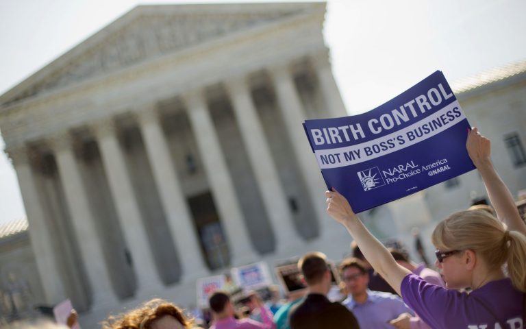 A demonstrator holds up a sign outside the Supreme Court in Washington on the day the court decided in the Hobby Lobby case to relieve businesses with religious objections of their obligation to pay for women's contraceptives among a range of preventive services the new health law calls for in their health plans. (AP/Pablo Martinez Monsivais)