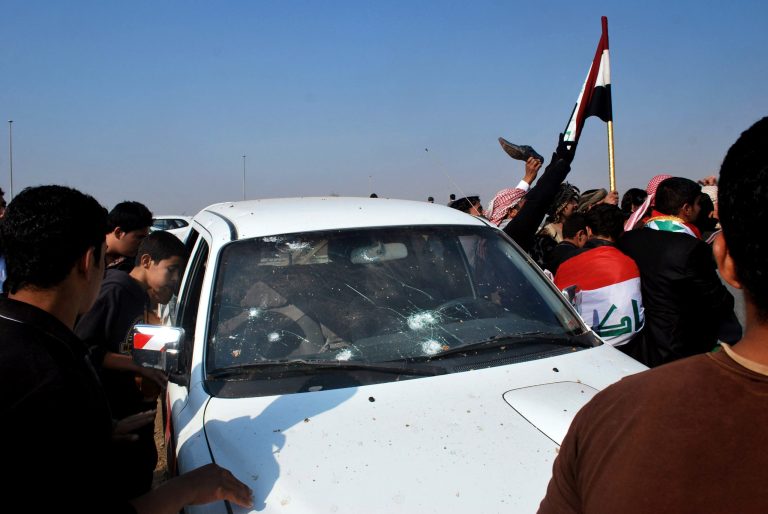   Protesters inspect a damaged vehicle during a demonstrations in Ramadi, 70 miles (115 kilometers) west of Baghdad, Iraq, Sunday, Dec. 30, 2012. Gunshots wounded at least two people Sunday at demonstrations in western Iraq when bodyguards protecting a senior Sunni politician opened fire to disperse protesters, a local official said, marking the first casualties in a week of rallies. (AP Photo)  