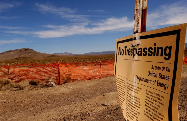 A 'no trespassing' sign warns people to stay away from the proposed nuclear waste dump site of Yucca Mountain (L) February 7, 2002 at Nellis Air Force Base, located approximately 90 miles north of Las Vegas, NV. Â (Photo by David McNew/Getty images)