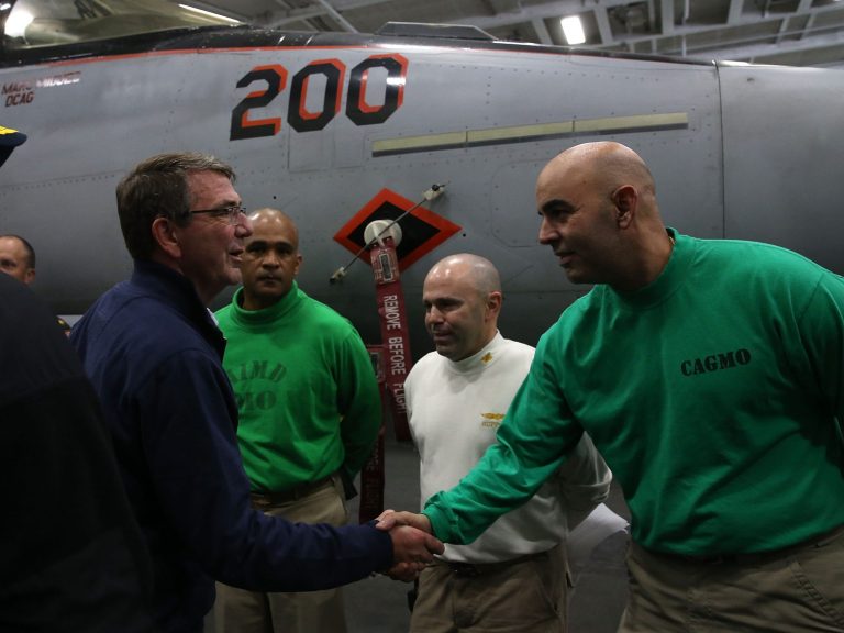 Defense Secretary Ashton Carter, left, greets crew members while visiting the the USS Eisenhower in the Atlantic Ocean off the coast of Virginia on Dec. 10. (Mark Wilson/Pool Photo via AP)