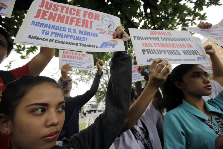 Protesters display placards at a rally at the U.S. Embassy in Manila to reiterate their demand to take custody of a U.S. Marine who is a suspect in the killing of a Filipino transgender Friday, Oct. 17, 2014 in the Philippines.  Police filed a murder complaint two days ago against U.S. Marine Pfc. Joseph Scott Pemberton accused of killing Jennifer Laude, whose former name was Jeffrey. The killing becomes an emotional case and is expected to test the country's military ties with the United States. (AP Photo/Bullit Marquez)