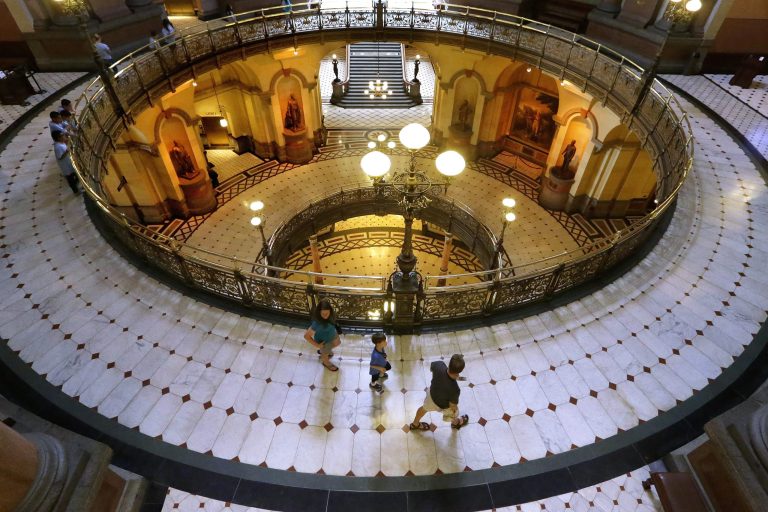 Visitors tour the rotunda at the Illinois State Capitol Thursday, June 5, 2014, in Springfield, Ill. Illinois state agencies are restricting spending and bracing for the worst after lawmakers approved a budget that uses accounting gimmicks and punts on crucial decisions about where to find revenue until after the November election. (AP Photo/Seth Perlman)