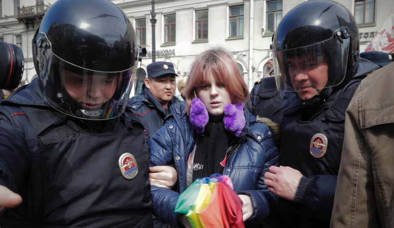 FILE - In this Monday, May 1, 2017 file photo, a gay rights activist holding a rainbow umbrella is detained by police during a rally marking May Day in downtown St. Petersburg, Russia. In the past two months, there have been large-scale detentions of gay men in Nigeria and Bangladesh, and chilling accounts of roundups and torture of scores of gays in Chechnya. In Indonesia, a major police raid on a gay sauna was followed two days later by the public caning of two gay men.