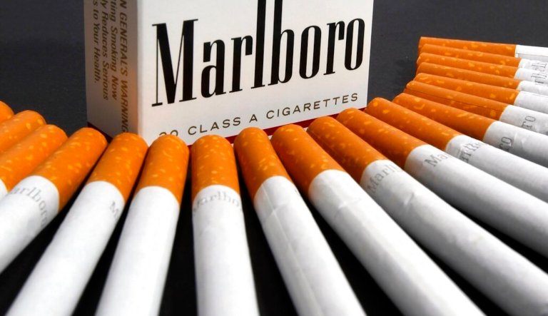 An employee checks cigarettes during production at a factory.
