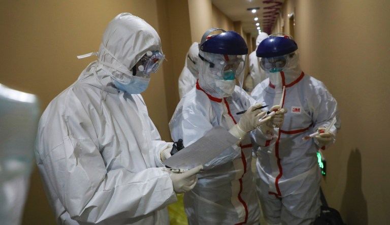 Un trabajador mÃ©dico escribe en un tubo tras recoger una muestra de un paciente en un hotel utilizado para colocar a personas en cuarentena en Wuhan, en la provincia central de Hubei, China, el martes 4 de febrero de 2020.