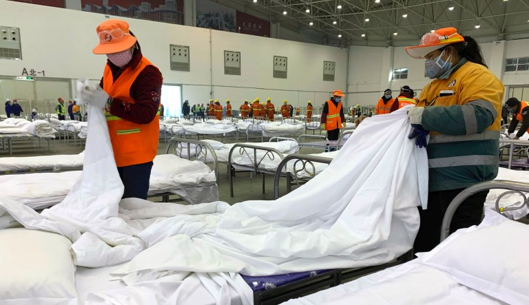 Trabajadores preparando camas en un centro de convenciones convertido en hospital temporal en Wuhan, en la provincia china de Hubei, el martes 4 de febrero de 2020. 