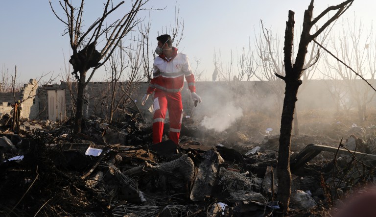 A rescue worker searchs the scene where an Ukrainian plane crashed in Shahedshahr southwest of the capital Tehran, Iran, Wednesday, Jan. 8, 2020. A Ukrainian airplane carrying 176 people crashed on Wednesday shortly after takeoff from Tehran's main airport, killing all onboard. 
