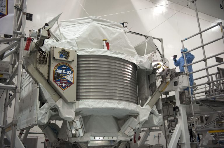 FILE -In this undated picture made available by NASA, a technician examines the Alpha Magnetic Spectrometer at Kennedy Space Center in Cape Canaveral, Fla.. The cosmic ray detector was mounted on the International Space Station, searched the universe and shall help to explain how everything came to be. CERN , the European Organization for Nuclear Research, released first results of the experiment Wednesday April 3, 2013. (AP Photo/NASA, Glenn Benson)