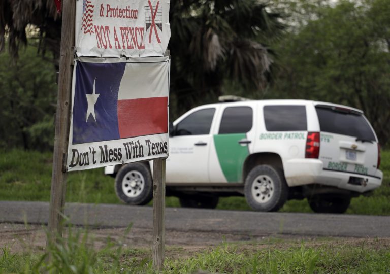 A U.S. Customs and Border Patrol agent passes a sign protesting a border fence, Monday, Nov. 14, 2016, in Edinburg, Texas. (AP Photo/Eric Gay)