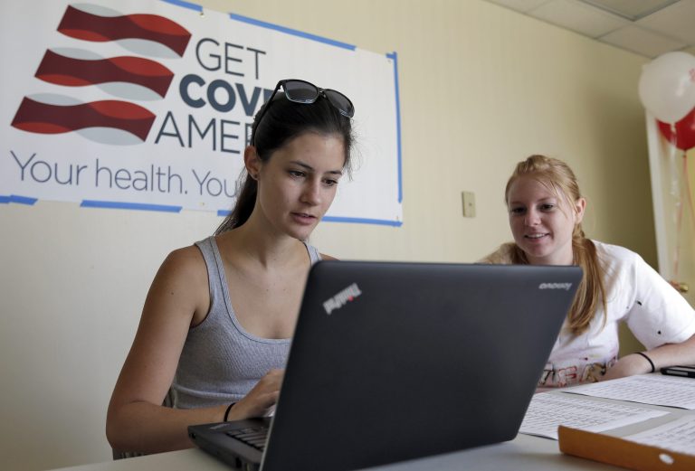 Ashley Hentze, left, gets help signing up for the Affordable Care Act from Kristen Nash, a volunteer with Enroll America. (AP/Chris O'Meara)