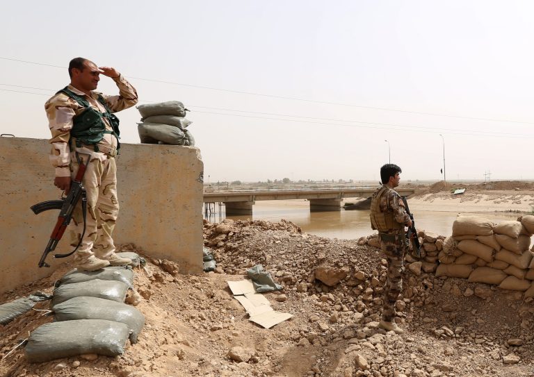 Kurdish Peshmerga fighters stand guard with their weapons as they patrol the front line with the Islamic State group near the Rashad Bridge, which connects the provinces of Salah al-Din and Kirkuk, 290 kilometers (180 miles) north of Baghdad, Iraq, Monday, Sept. 29, 2014. (AP Photo/Hadi Mizban)