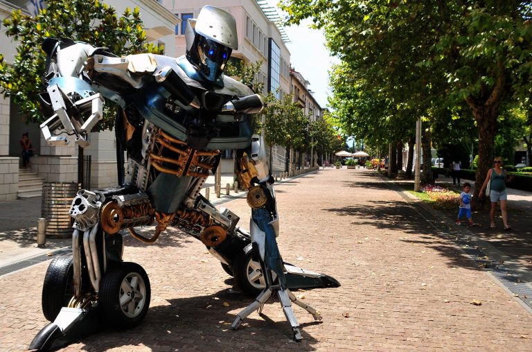 In this picture taken on Wednesday, July 23, 2014, a towering figure, mostly made of old car parts and other waste is seen in Podgorica, Montenegro. Giant scrap-metal sculptures of popular Autobots, Decepticons and the evil Megatron himself are on show at several locations in the Montenegrin capital of Podgorica _ work of a young artist who saw a new role for his childhood heroes. (AP Photo/Risto Bozovic)