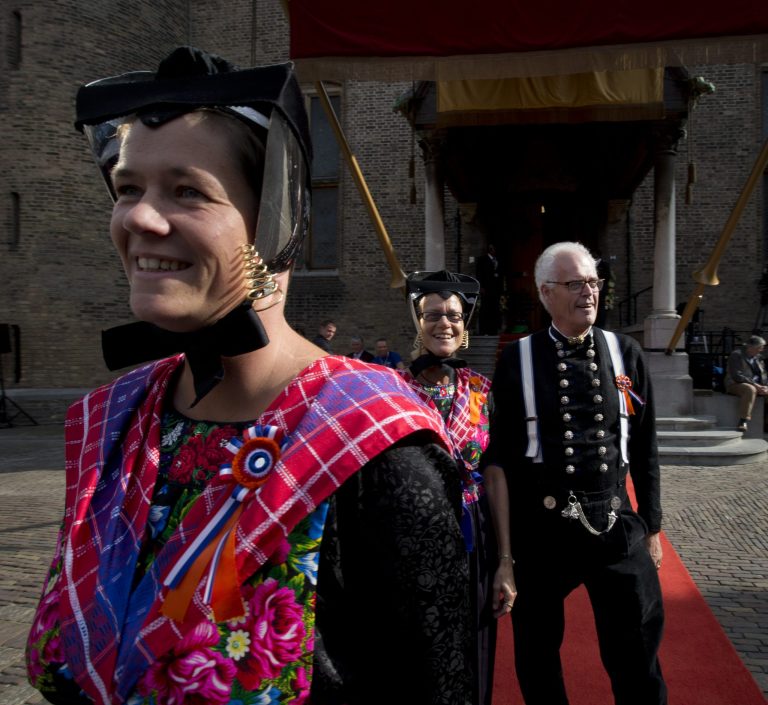 People in traditional Dutch clothes pose for pictures outside the 13th century 