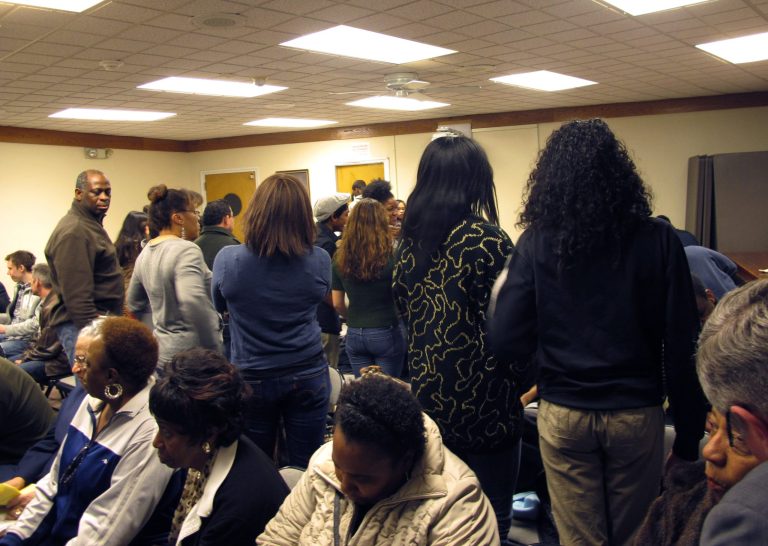 Supporters of public schools turn their backs on the East Ramapo school board during a meeting on Tuesday, March 19, 2013, in Spring Valley, N.Y. Allegations of racism and anti-Semitism are afflicting the district, where the board is dominated by ultra-Orthodox Jews and the public school children are mostly black and Hispanic. (AP Photo/Jim Fitzgerald)