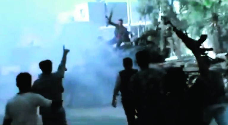 In this image made from amateur video released by the Ugarit News and accessed Monday, July 23, 2012, Free Syrian Army soldiers react after destroying two military tanks during clashes with Syrian government troops in Aleppo, Syria. The Syrian regime acknowledged for the first time Monday that it possessed stockpiles of chemical and biological weapons and said it will only use them in case of a foreign attack and never internally against its own citizens. (AP Photo/Ugarit News via AP video) TV OUT, THE ASSOCIATED PRESS CANNOT INDEPENDENTLY VERIFY THE CONTENT, DATE, LOCATION OR AUTHENTICITY OF THIS MATERIAL
