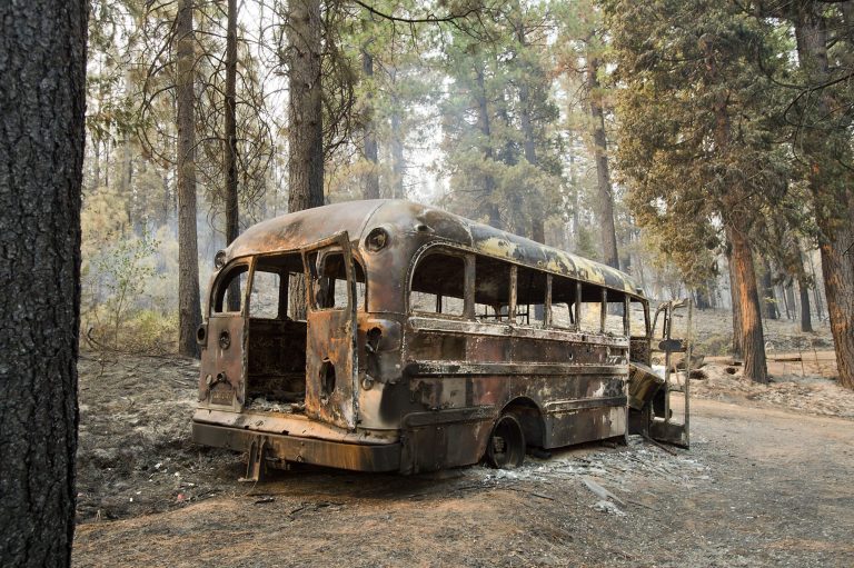A burned bus sits in an area struck by the King Fire near Icehouse in El Dorado County, Calif. on Friday, Sept. 19, 2014. Heavy rains this week and the prospect of more wet weather over the weekend are raising hopes that firefighters will get full containment quickly on the massive wildfire in a heavily forested region of the Sierra east of Sacramento. (AP Photo/The Sacramento Bee, Randall Benton)