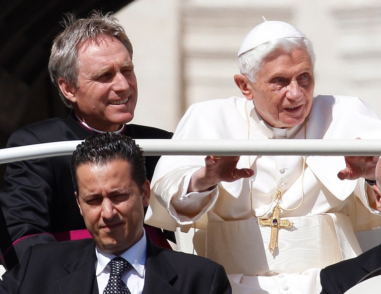   FILE - In this file photo taken Wednesday, May 2, 2012, Pope Benedict XVI, right, arrives in St. Peter's square at the Vatican for a general audience as his then-butler Paolo Gabriele, bottom, and his personal secretary Georg Gaenswein sit in the car with him. The Vatican has summoned journalists for a briefing on Saturday Dec. 22, 2012, for what Italian media report is expected to be the announcement of a pardon for the former butler, Gabiele, who was convicted in October 2012 of aggravated theft after steeling the pontiff's personal papers and leaking them to the media in a bid to expose the 