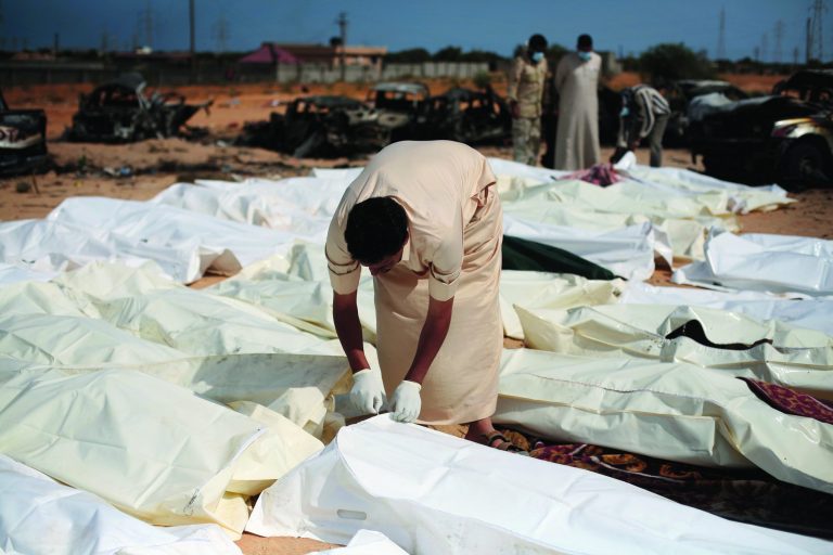 FILE - In this Oct. 22, 2011 file photo, a revolutionary fighter zips a body bag containing one of nearly 30 bodies of Gadhafi loyalists killed in Sirte, Libya, during the city's fall. Libyan rebels appear to have 